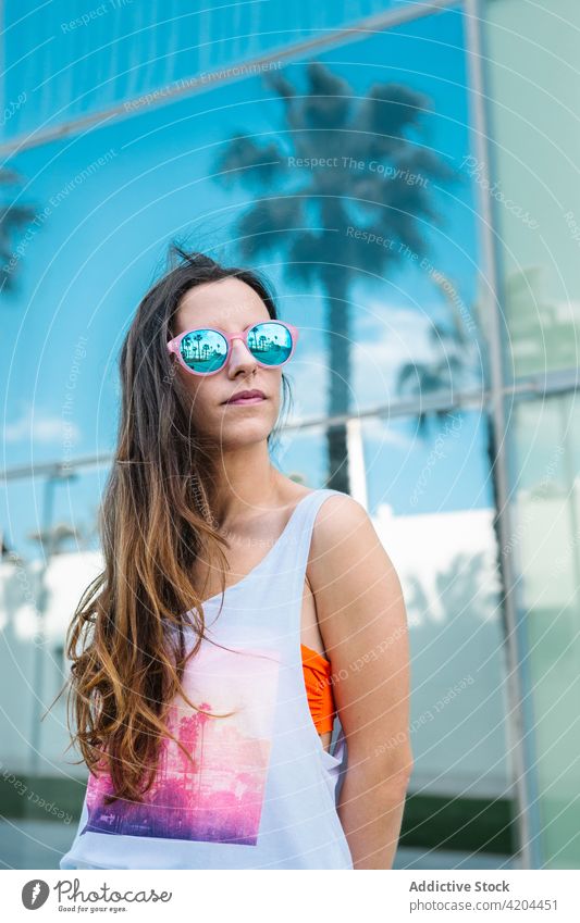 Stilvolle Frau mit Sonnenbrille genießt den Sommertag trendy selbstbewusst Mode Brille sonnig lange Haare Lifestyle jung modern urban Persönlichkeit Vorschein