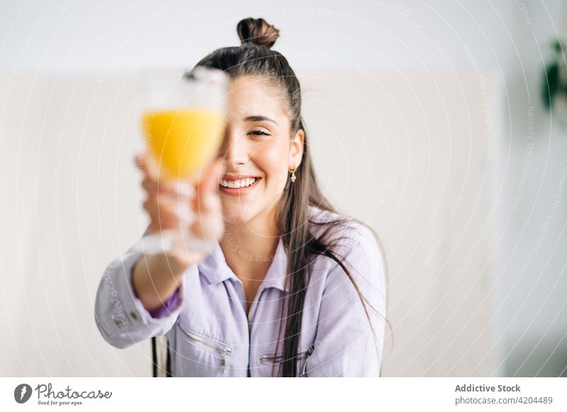 Glückliche Frau mit leckerem Orangensaft im Haus Glas Saft Auge abdecken heiter Getränk offen genießen heimwärts Porträt ausdehnen Lächeln froh herzlich
