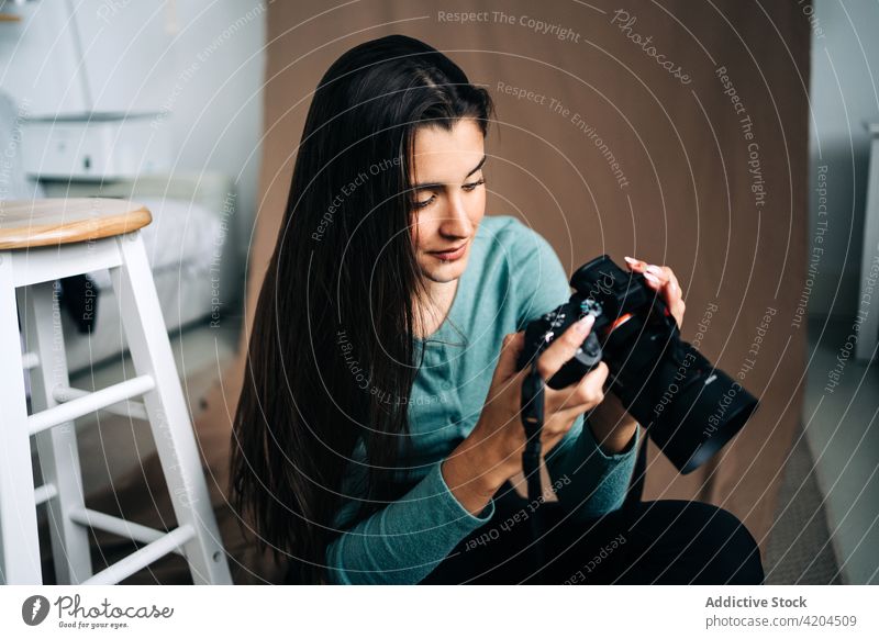 Fotograf mit Fotokamera auf zerknittertem Stoff Fotoapparat digital Stil modern professionell ruhen Frau Textil Porträt Gerät Gurt Zeitgenosse kreativ Design