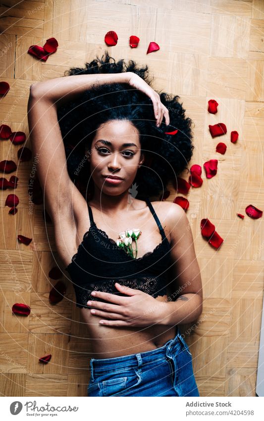 Ethnische Frau mit Rosenblüten Roséwein Blume romantisch Haufen Angebot Valentinsgruß Blütenblatt geblümt filigran ethnisch Frisur Afro-Look schwarz