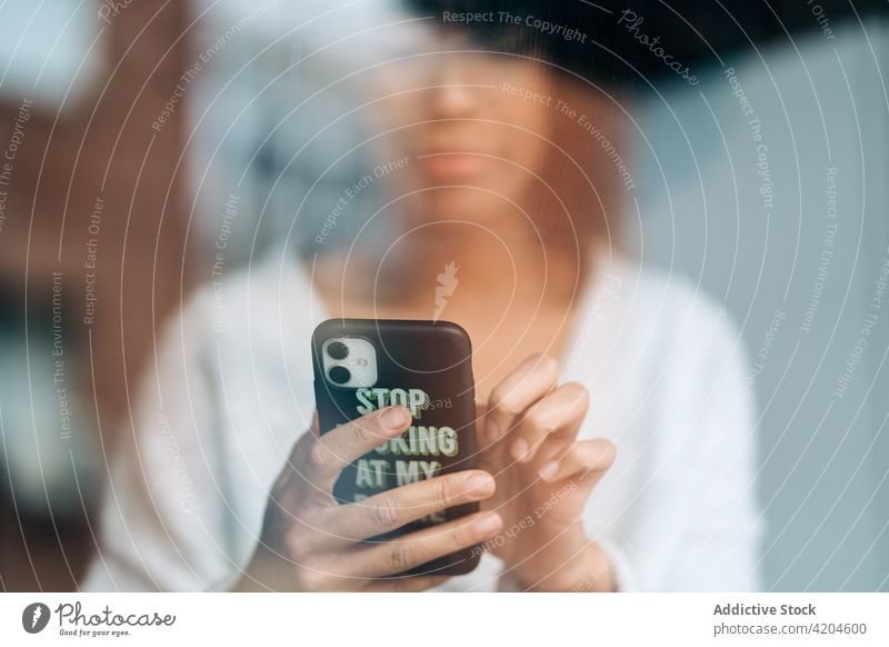 Ethnische Frau, die zu Hause auf ihrem Smartphone surft Textnachricht Nachricht benutzend Browsen Surfen Internet heimwärts soziale Netzwerke ethnisch schwarz