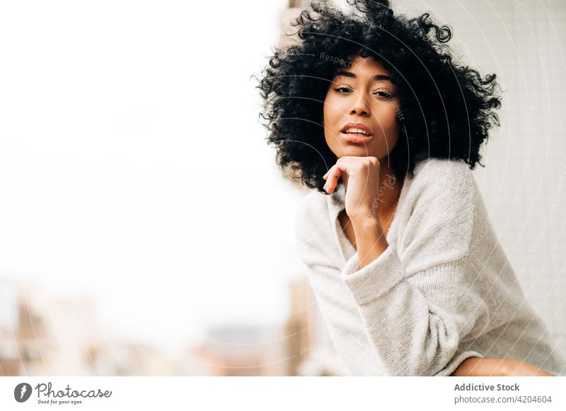 Gelassene schwarze Frau auf Balkon stehend Gelassenheit Terrasse verträumt ruhig Afro-Look Vorschein Frisur friedlich ethnisch Afroamerikaner fettarm Reling