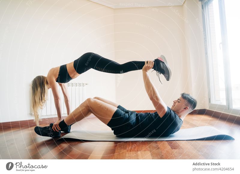 Flexibles Paar bei Acroyoga-Übung Akro-Yoga Training Gleichgewicht Fitness üben gymnastisch akrobatisch abstützen Frau Sportkleidung Athlet Raum Unterlage