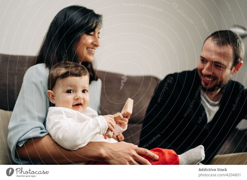 Niedliches Baby sitzt auf den Knien der Mutter und spielt mit dem Vater Familie spielen Verschluss Spielzeug Liebe Zuneigung Partnerschaft Glück Elternschaft
