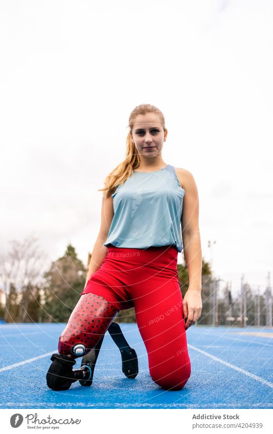 Zufriedene Sportlerin mit bionischer Beinprothese im Stadion Prothesen Athlet Bionik Läufer paralympisch künstlich Glied Frau professionell passen Amputierte