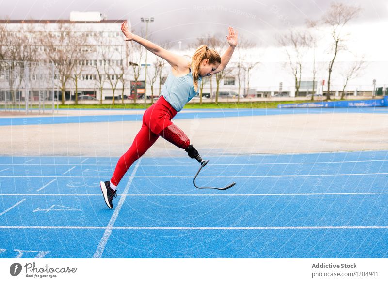 Energiegeladene Sportlerin mit Beinprothese läuft im Stadion laufen Prothesen Läufer paralympisch Athlet Training Sprinter Frau Bionik professionell Rennbahn