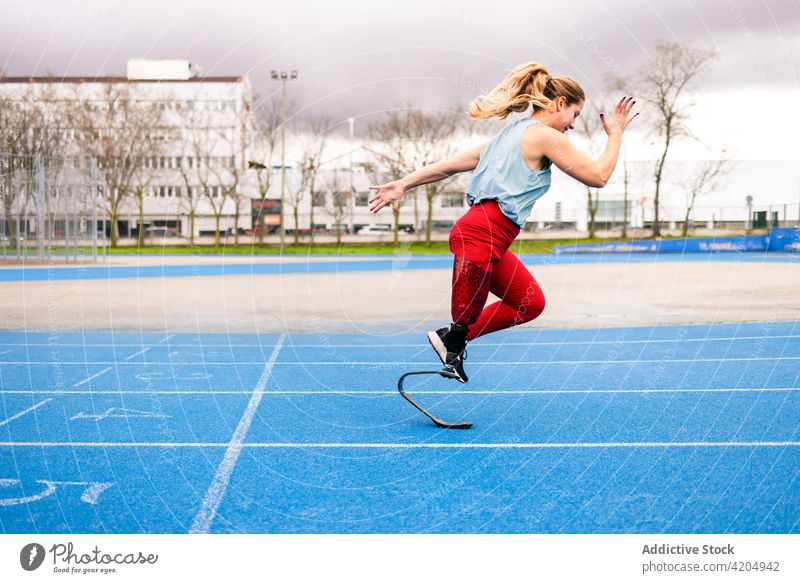 Energiegeladene Sportlerin mit Beinprothese läuft im Stadion laufen Prothesen Läufer paralympisch Athlet Training Sprinter Frau Bionik professionell Rennbahn