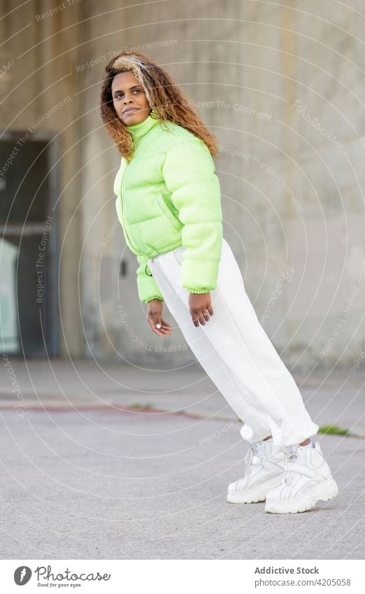 Ethnische Frau in trendigem Outfit steht auf städtischer Straße trendy Hipster Stil urban Farbe Mode modern fallen Steigung Körperhaltung jung Afroamerikaner