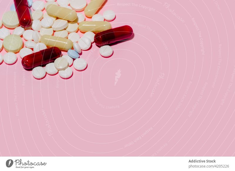 Haufen von verschiedenen Pillen auf rosa Hintergrund Tablette Medikament Kapsel farbenfroh Apotheke Medizin sortiert mehrfarbig anders viele Pharma Kulisse