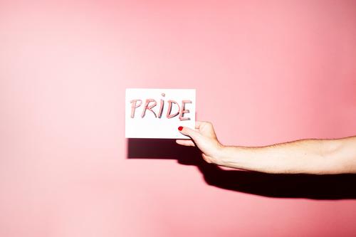 Gesichtslose Person zeigt Papier mit PRIDE-Text Homosexualität Stolz manifestieren gleich Toleranz schwul lesbisch Konzept lgbt Nagellack Aufschrift Hand zeigen