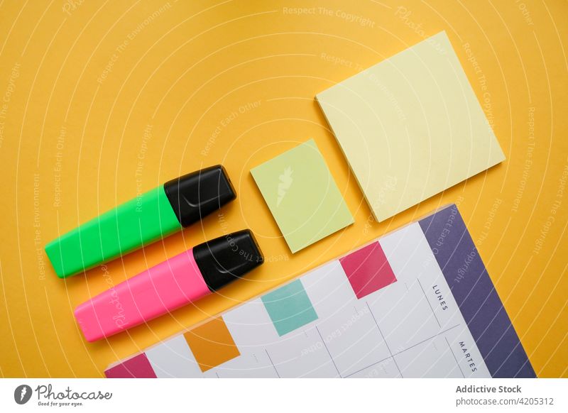 Buntes Büromaterial auf gelbem Hintergrund Kalender Planer Markierung Haftnotiz Vorrat Farbe Kulisse Zeitplan organisieren farbenfroh Schreibwarenhandlung