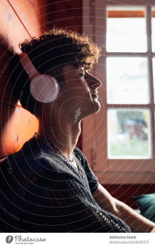 Mann hört Musik mit Kopfhörern in einem Bungalow zuhören genießen Freizeit Augen geschlossen Porträt benutzend Gerät Klang Audio meloman Zeitvertreib Wochenende