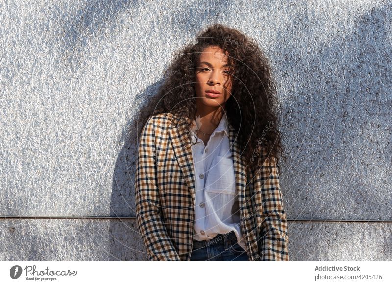 Ruhige schwarze Frau lehnt an einer Betonwand besinnlich Straße selbstbewusst Windstille urban Großstadt nachdenken nachdenklich Fokus Afroamerikaner trendy
