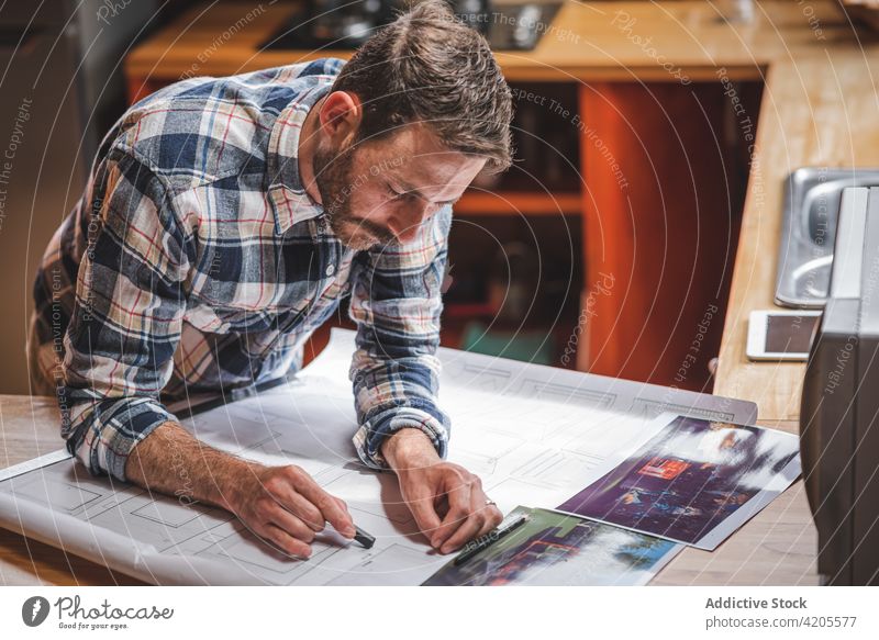 Männlicher Architekt zeichnet Skizzen auf Papier am Tisch zeichnen Bauplan Mann Haus Projekt Gebäude Plan männlich heimwärts Zeichnung professionell Job