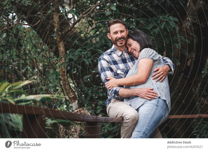 Glückliches Paar, das sich auf der Terrasse eines Hauses im Wald umarmt Lachen Umarmen heiter Liebe hölzern romantisch Zusammensein Wälder Bonden Natur