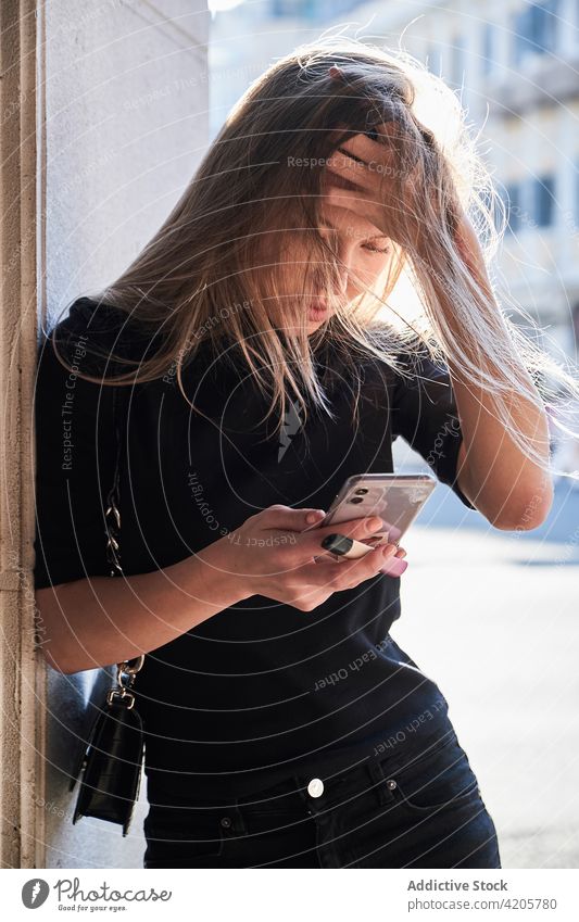 Frau benutzt ihr Smartphone und schaut besorgt Russisches Mädchen allein schön blond Großstadt Stadtleben Stadtbild Tag Stadtzentrum elegant formal lange Haare
