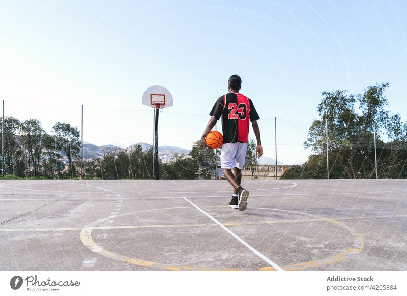 Anonymer selbstbewusster schwarzer Basketballspieler auf dem Sportplatz Streetball Mann Spieler Ball Spielplatz Bestimmen Sie Gericht Athlet männlich ethnisch