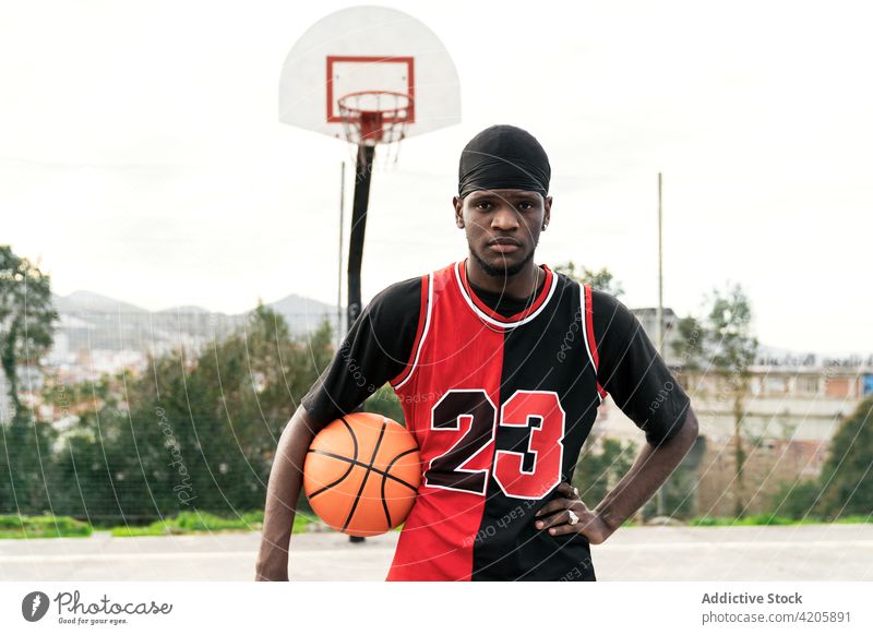 Selbstbewusster schwarzer Basketballspieler auf dem Sportplatz Streetball Mann Spieler Ball Spielplatz ernst Bestimmen Sie Gericht Athlet männlich ethnisch