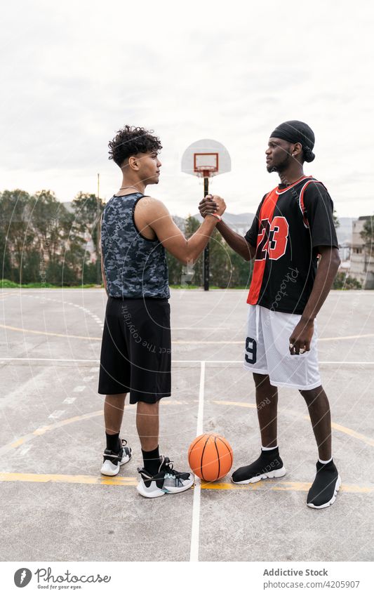 Schwarze männliche Basketballspieler geben sich auf dem Spielfeld die Hand Spieler Hände schütteln Männer Gruß gestikulieren Streetball Gericht Spielplatz