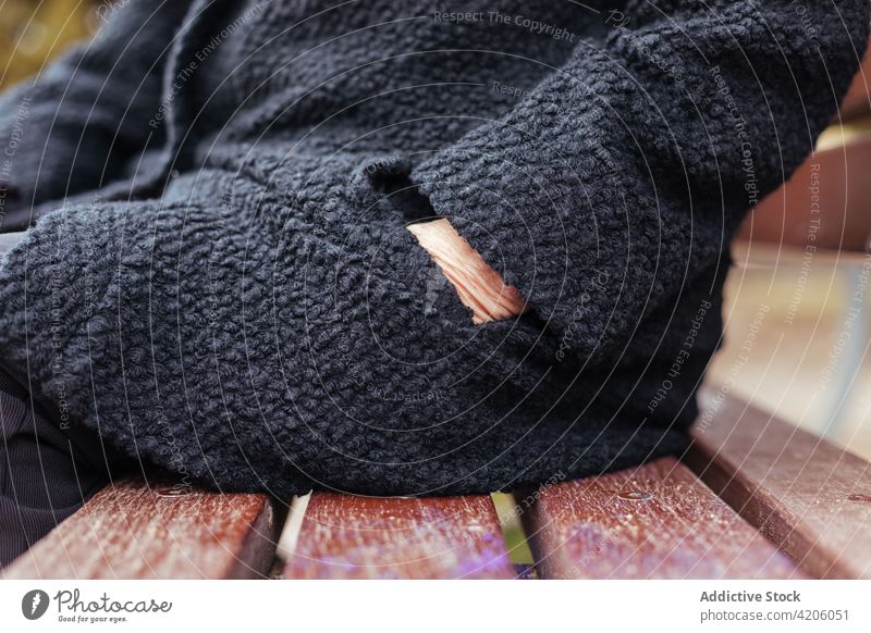 Seitenansicht einer anonymen älteren Frau, die in ihre Manteltasche greift Hand Tasche schwarz gesichtslos unkenntlich Detailaufnahme Sitzen Winter aussruhen
