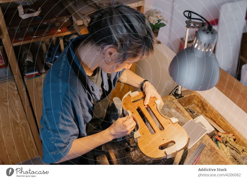 Handwerkerin, die den Geigenkörper an der Werkbank befestigt Hobelbank Werkstatt befestigen Instrument Arbeit professionell Kunst Frau Tisch Job Hobby