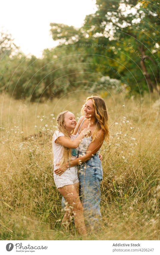 Frau umarmt kleine Schwester auf dem Feld Geschwister Partnerschaft Angebot Teenager Mädchen Zusammensein Umarmung Wiese Sommer Liebe Umarmen Glück Bonden