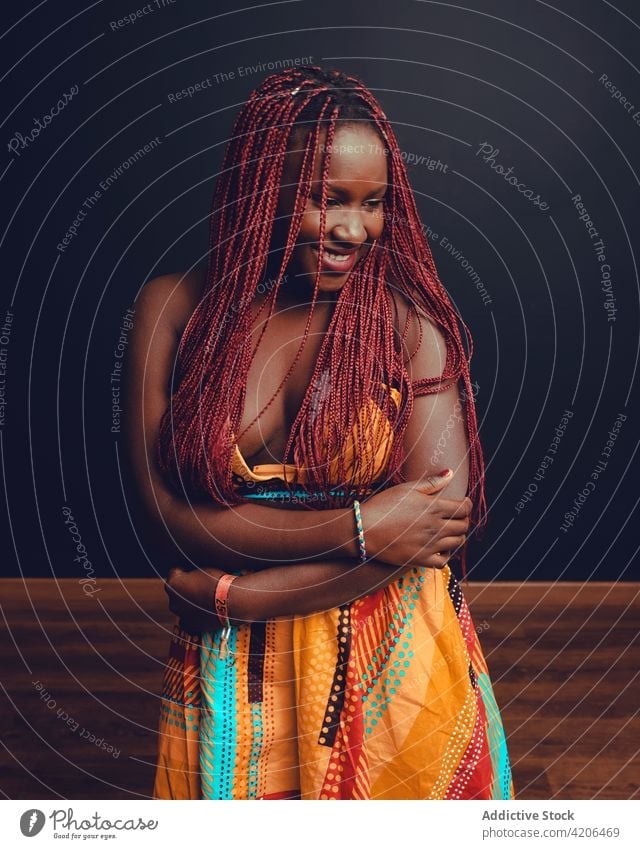 Inhalt Schwarze Frau mit Zöpfen im Studio Geflecht Frisur heiter Vorschein Schönheit Teint lange Haare rosa Haare Lächeln ethnisch schwarz Afroamerikaner