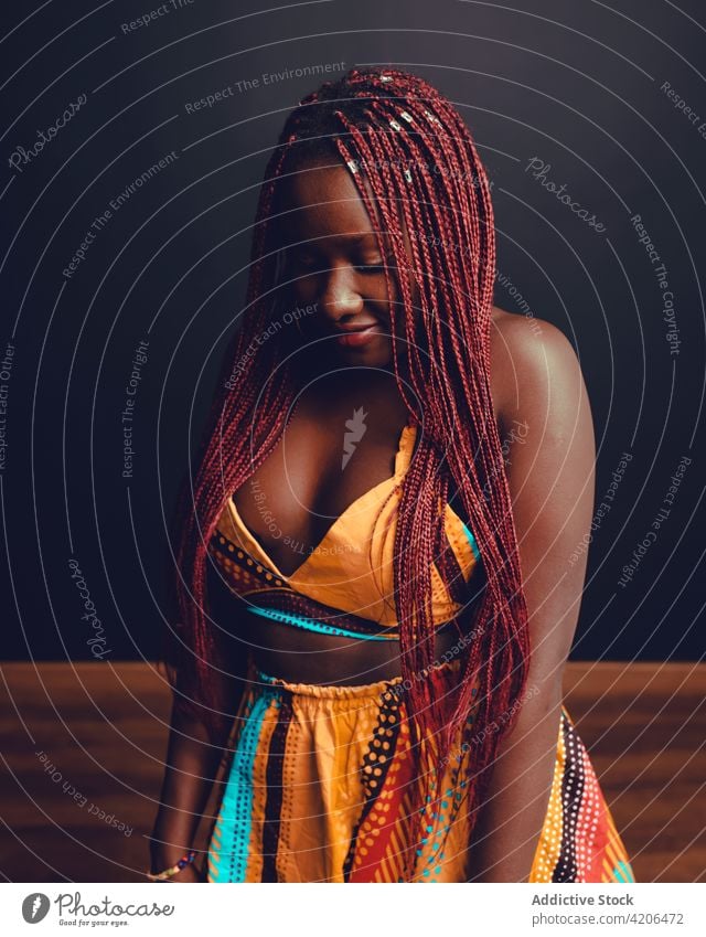 Inhalt Schwarze Frau mit Zöpfen im Studio Geflecht Frisur heiter Vorschein Schönheit Teint lange Haare rosa Haare Lächeln ethnisch schwarz Afroamerikaner