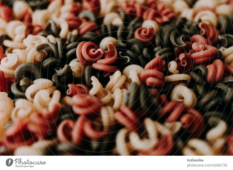 Spiralförmige Trockennudeln in drei verschiedenen Farben. Spätzle Nahaufnahme Makkaroni Italienisch Gesundheit Mahlzeit rot Lebensmittel gelb süß grün