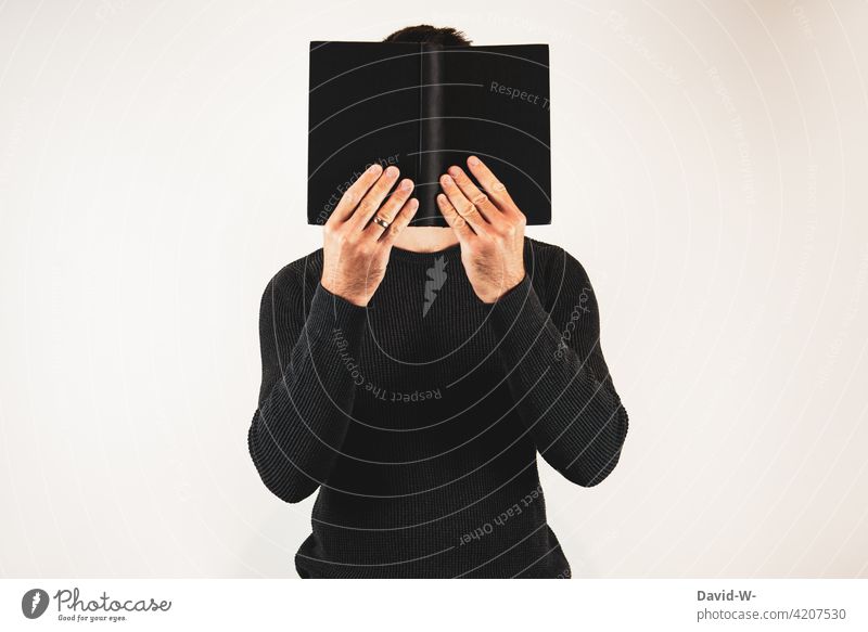 Mann mit Buch lesen weiterbilden verstecken Roman Leser anonym vertieft Lesestoff Wissen