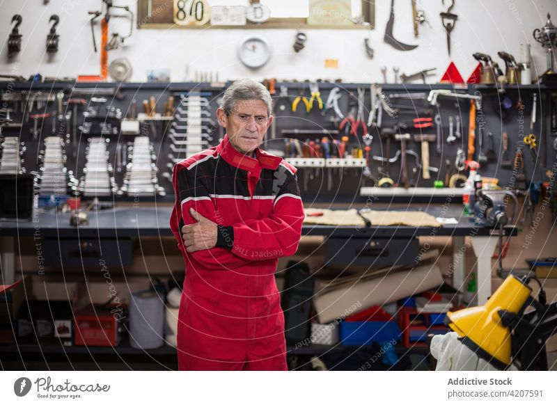 Älterer Mechaniker in professioneller Werkstatt mit Werkzeugen Arbeit Instrument Mann Fähigkeit Reparatur Senior gealtert männlich älter Dienst Flugzeugwartung