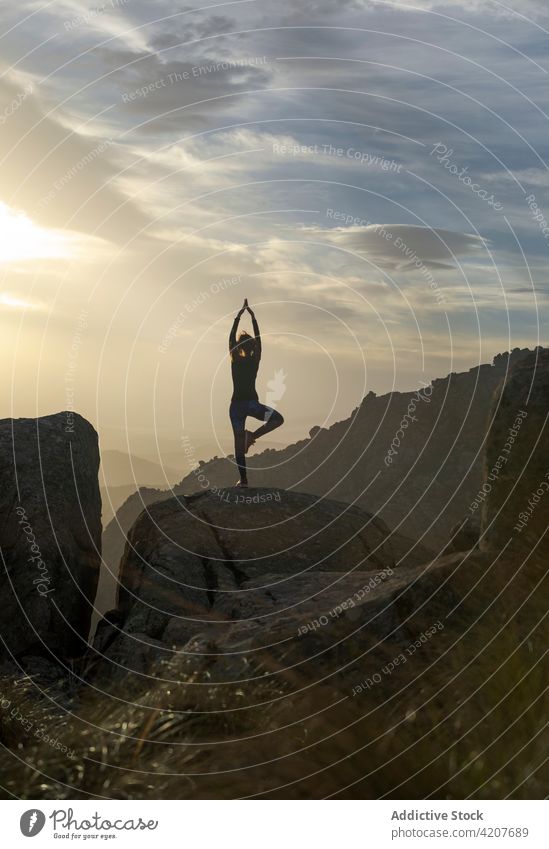 Frau in Vrksasana auf einer Bergkuppe Yoga Baum mit Armen nach oben Pose Erholung meditieren Natur beweglich selbstbewusst Berge u. Gebirge vrksasana