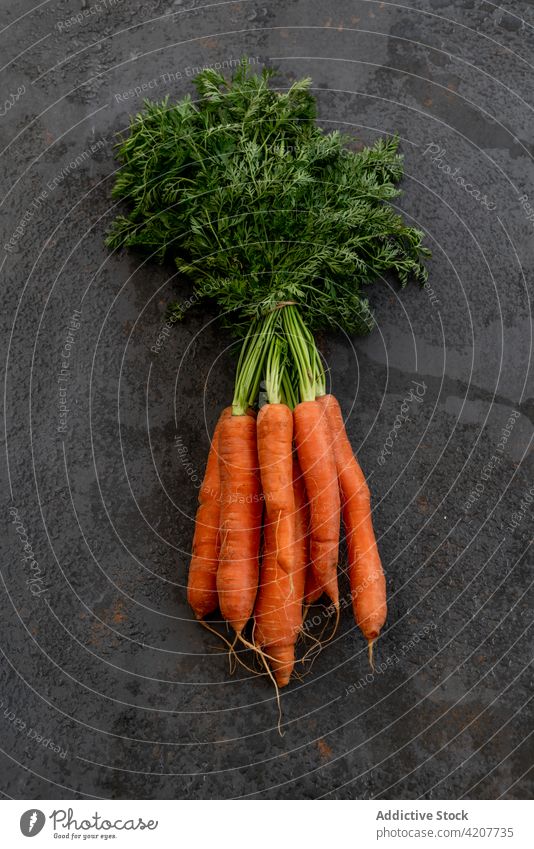 Bündel frischer Karotten auf schwarzem Tisch Möhre Haufen Gemüse reif Ernte Vitamin Lebensmittel Gesundheit organisch natürlich essbar Ernährung schäbig