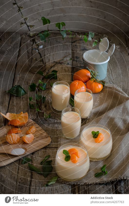 Süßes Mandarinenmousse in Gläsern auf dem Tisch Mousse Dessert dienen Leckerbissen süß Bestandteil Zitrusfrüchte Frucht hölzern Gesundheit geschmackvoll Küche
