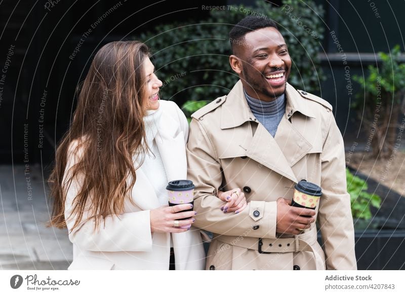 Glückliches multiethnisches Paar in stilvoller Kleidung mit Kaffee zum Mitnehmen Stil Imbissbude Tasse urban Zusammensein Mode Partnerschaft romantisch Liebe