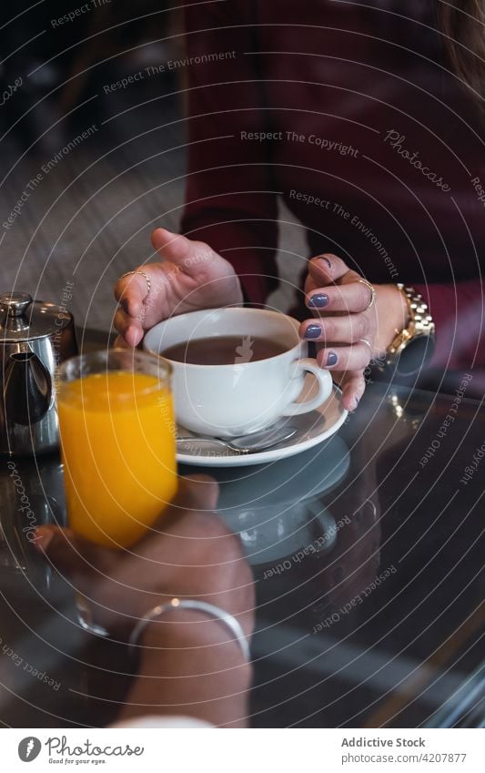 Multiethnisches Paar mit Getränken in einem Cafe Frühstück trinken Café Tee Saft Zusammensein Morgen Tasse Partnerschaft Liebe Heißgetränk aromatisch gemütlich