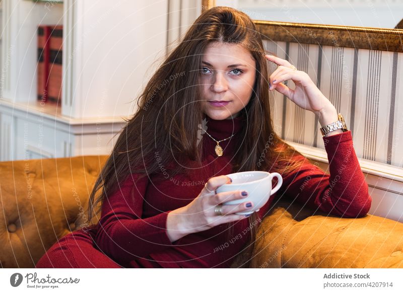 Frau mit Tasse Kaffee auf der Couch Café träumen Fenster besinnlich Glück trinken charmant verträumt Erwachsener Getränk sich[Akk] entspannen Freizeit Lifestyle