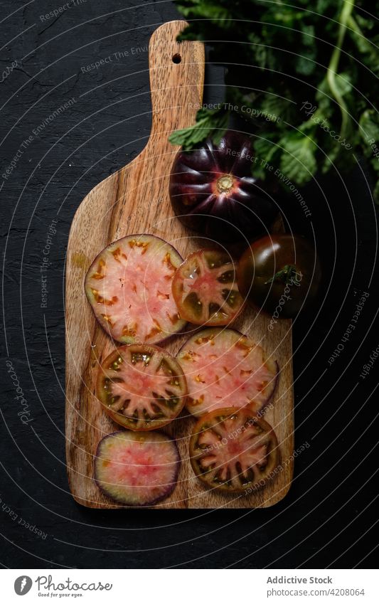 Schwarze Tomaten und Minze auf dem Schneidebrett schwarz frisch Gemüse Scheibe Lebensmittel natürlich vorbereiten Gesundheit Mahlzeit Bestandteil organisch
