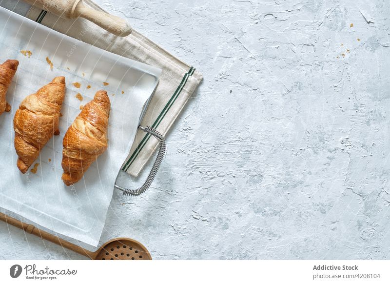 Appetitliche süße Croissants auf dem Tisch Dessert selbstgemacht Backpapier Küche Gebäck frisch gebacken Bäckerei Tablett lecker Metall appetitlich Ernährung