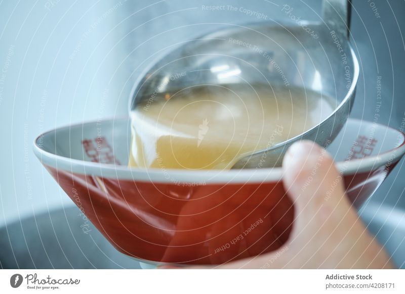 Zubereitung von Ramen-Suppe im Restaurant Gießen Küche professionell Makro Nudeln lecker Japanisches Essen Teller unerkannt Vorderansicht gesichtslos asiatisch
