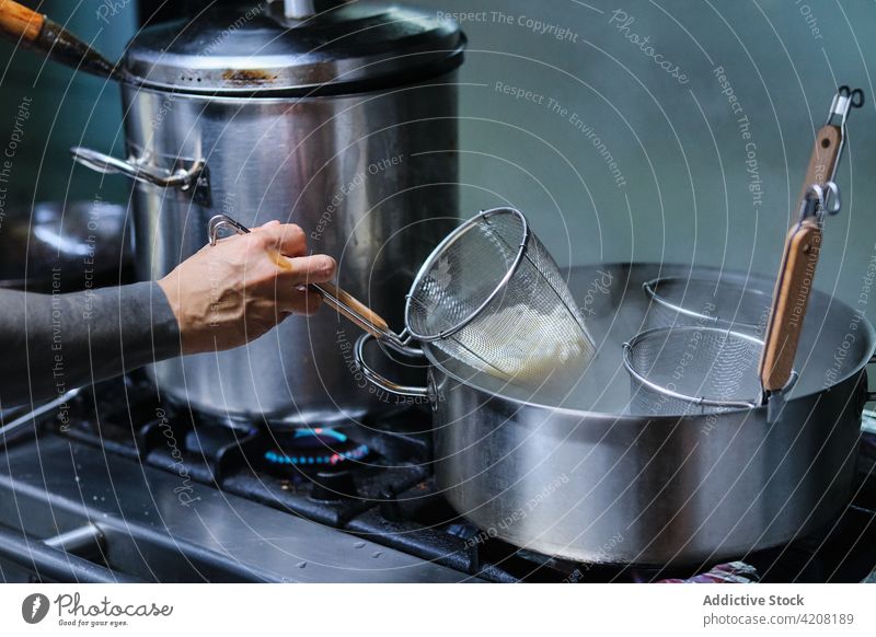 Chefkoch im japanischen Restaurant Küchenchef Waffen unerkannt Essen zubereiten gesichtslos Essstäbchen Nudeln vorbereitend Vorbereitung Nudelsiebe Draufsicht