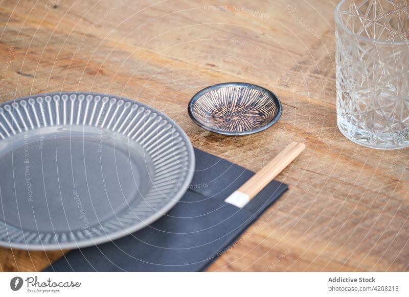 Teller und Stäbchen im japanischen Restaurant Essstäbchen Glas Tisch Japanisch japanisches Restaurant bereit vorbereitet Vorderansicht Holztisch Mahlzeit