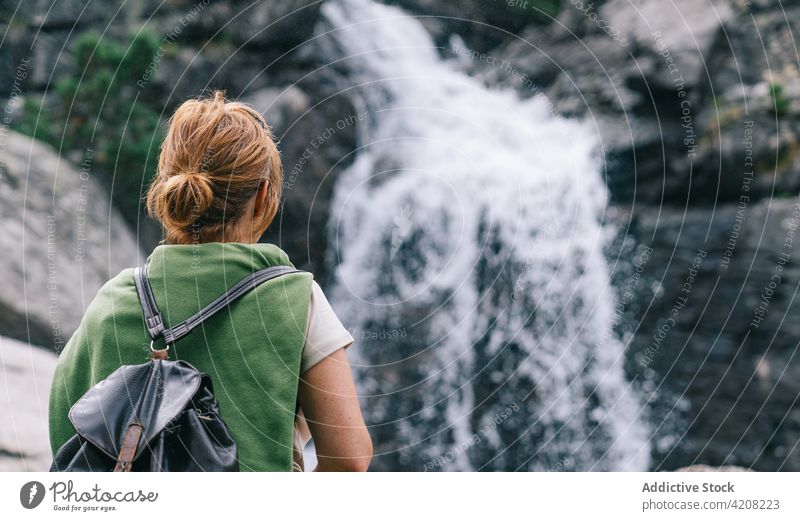 Unbekannte Frau an einem Wasserfall im Hochland Trekking stehen Tourismus Natur Aktivität Pyrenäen Kaskade Abenteuer platschen Rucksack bewundern Ausflug