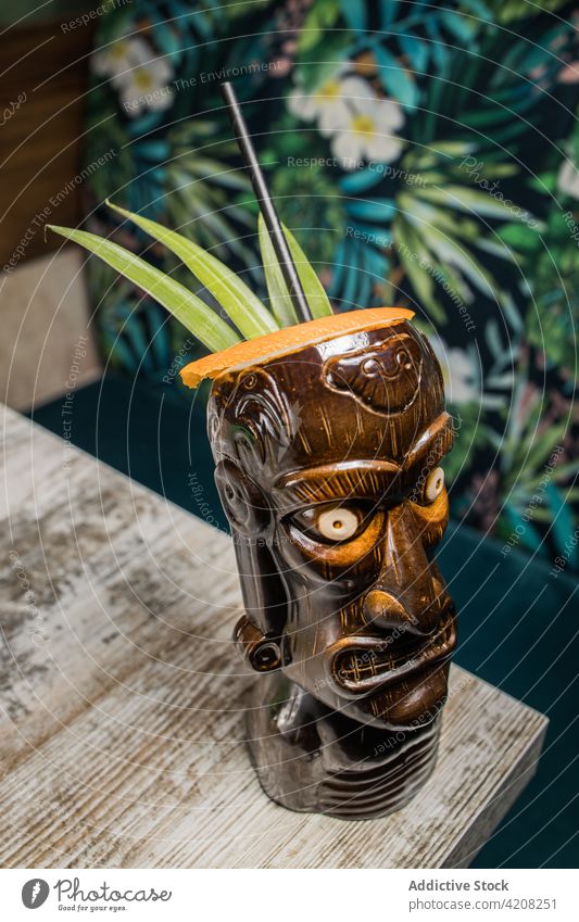 Polynesisches Tikiglas mit Cocktaileinlage tiki Becher Getränk Alkohol trinken Schnaps skulptural Blatt farbenfroh Stroh Erfrischung Glaswaren Aperitif braun