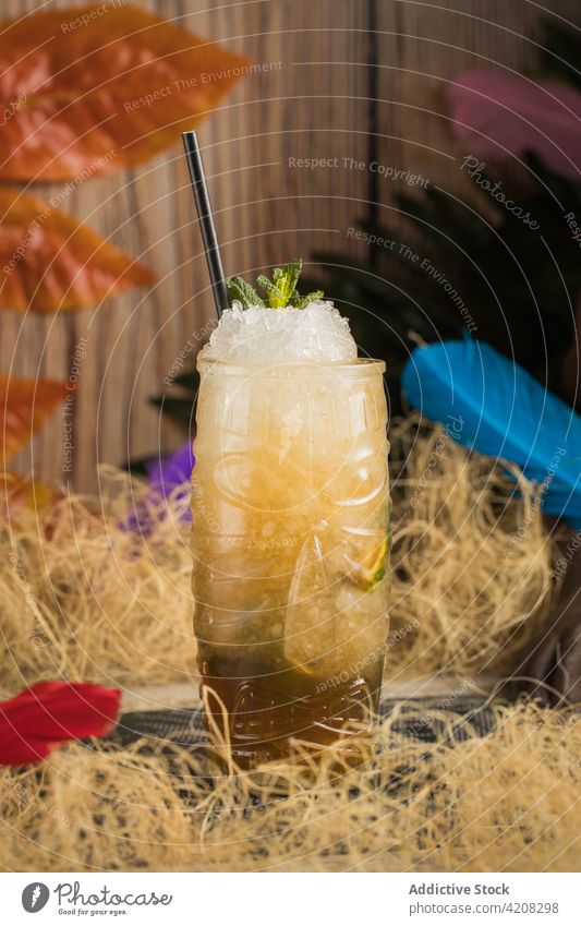 Tiki-Glas mit tropischem Cocktail und Eis tiki Becher Getränk Alkohol trinken Schnaps trocknen Gras Blatt farbenfroh Stroh Kraut Erfrischung Glaswaren Stoff