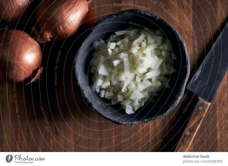 Schüssel mit gehackten Zwiebeln auf dem Tisch Schalen & Schüsseln Koch Küche hacken Bestandteil organisch Holz Messer rustikal geschnitten Nutzholz frisch