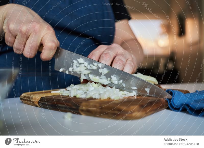 Hausfrau schneidet Zwiebel in der Küche Frau geschnitten Koch heimwärts organisch roh Schürze kulinarisch frisch Schneidebrett Messer Tisch Bestandteil Mahlzeit
