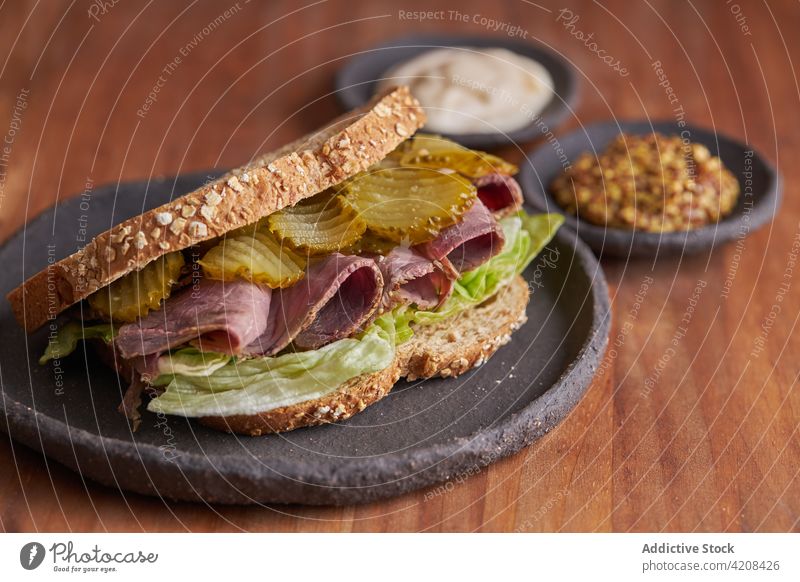 Nahaufnahme eines leckeren Sandwiches mit Pastrami, Salat, Schinken und Gurken Mittagessen Käse Belegtes Brot Pickles Fleisch Lebensmittel Snack Rindfleisch