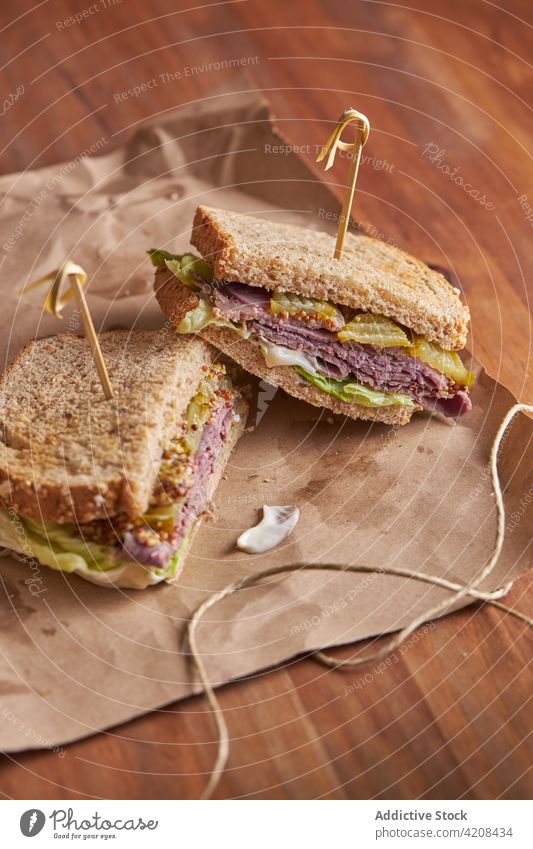 Nahaufnahme eines leckeren Sandwiches mit Pastrami, Salat, Schinken und Gurken Mittagessen Käse Belegtes Brot Pickles Fleisch Lebensmittel Snack Rindfleisch