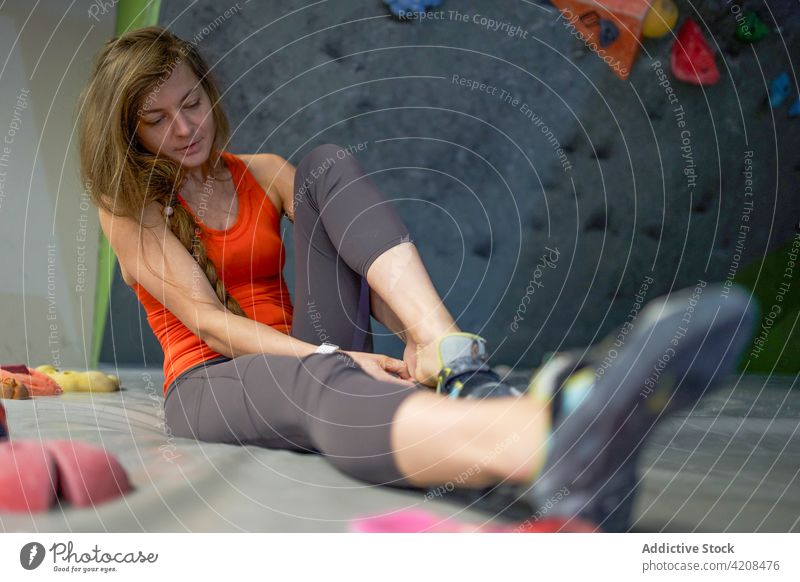 Junge Sportlerin bei der Vorbereitung auf die Kletterwand Alpinist Schuh vorbereiten Uniform Sportbekleidung Athlet Konzentration passen Frau Fokus Bouldern